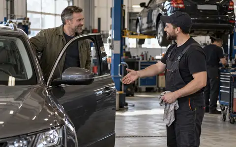 Давний клиент вернулся в мастерскую со своим автомобилем, мастер приветствует его